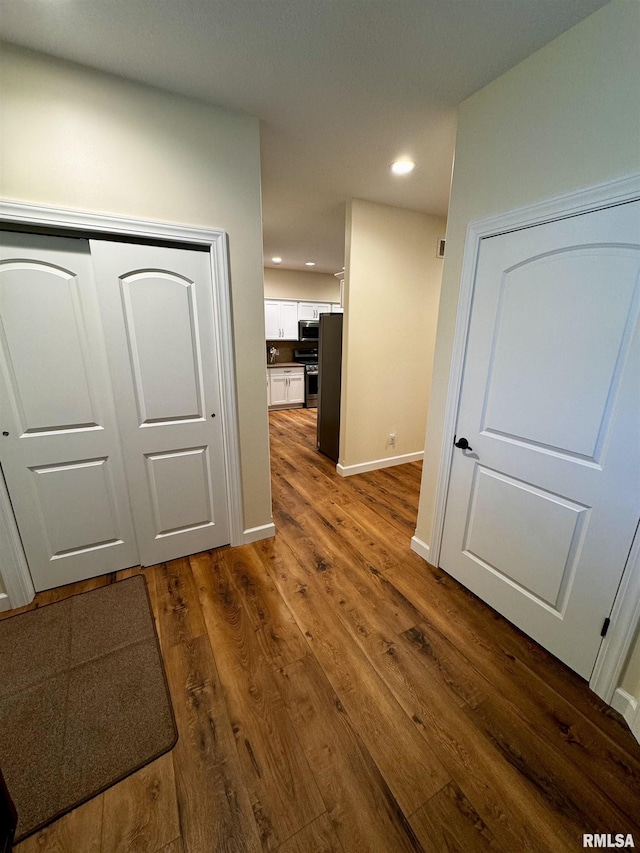 hallway with dark hardwood / wood-style flooring