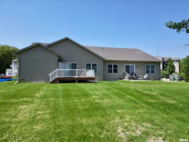 back of house with a lawn, a patio area, and a wooden deck