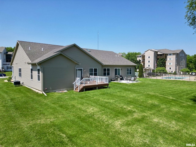 back of house with a lawn, a swimming pool side deck, and central AC unit