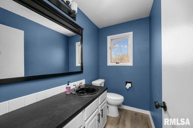 bathroom with hardwood / wood-style floors, vanity, and toilet