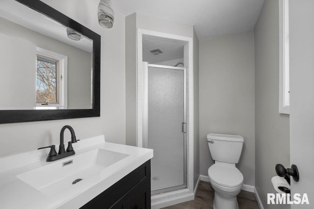 bathroom featuring vanity, toilet, and a shower with door