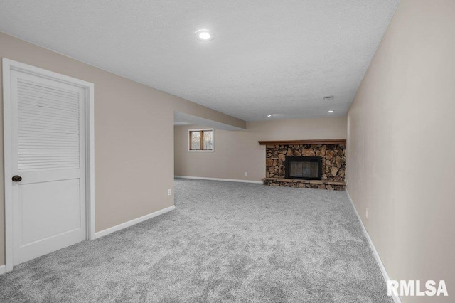 unfurnished living room featuring carpet flooring and a stone fireplace