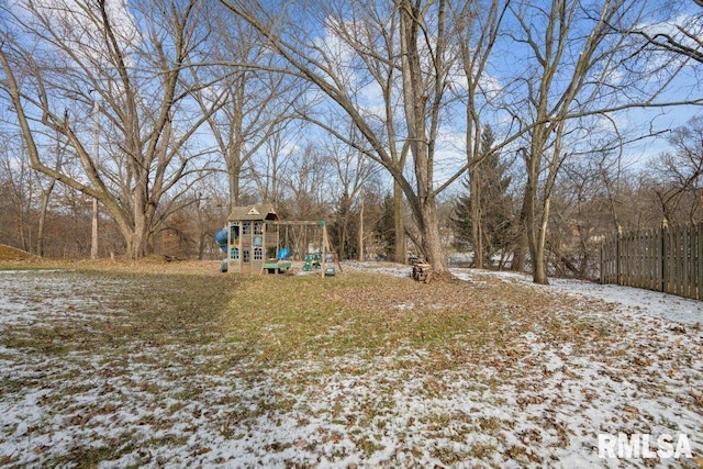 snowy yard featuring a playground