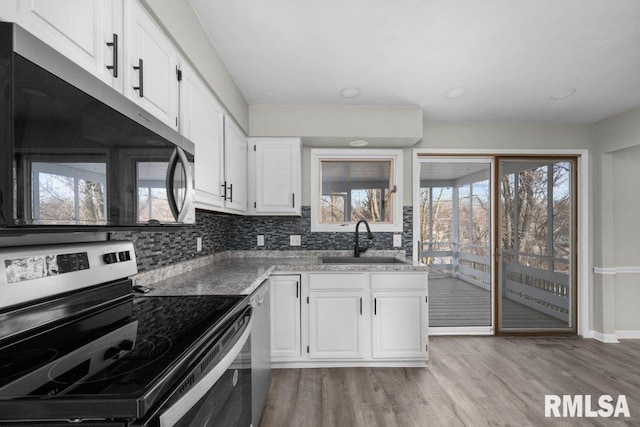 kitchen featuring light hardwood / wood-style floors, sink, white cabinetry, and stainless steel appliances