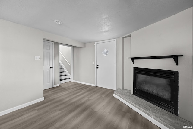 unfurnished living room with hardwood / wood-style floors and a textured ceiling