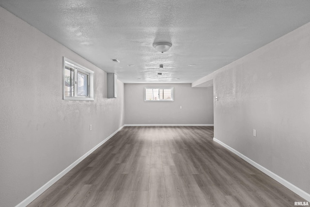 basement with dark wood-type flooring and a textured ceiling