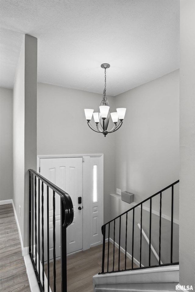 entrance foyer with wood-type flooring and an inviting chandelier