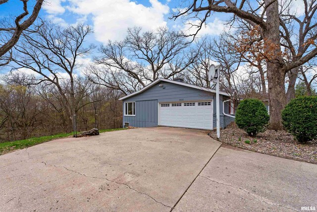 view of side of property with a garage and concrete driveway