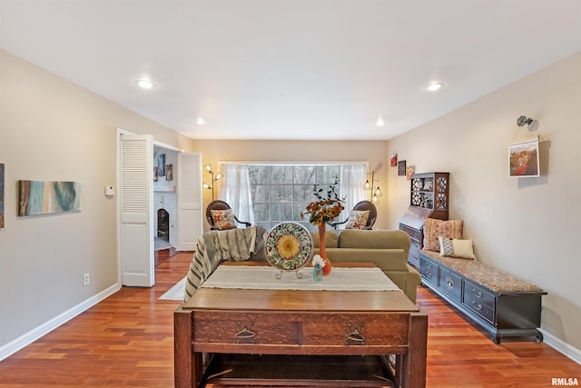 living room with wood finished floors, baseboards, and recessed lighting