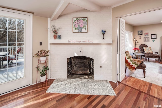 living room with hardwood / wood-style floors, lofted ceiling with beams, and a brick fireplace