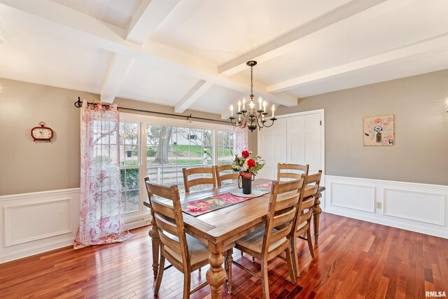 dining area with beamed ceiling, a wainscoted wall, a chandelier, and wood finished floors