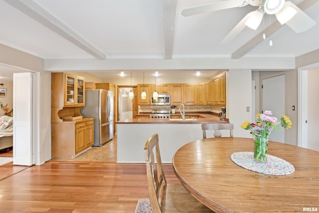 dining area featuring beamed ceiling, ceiling fan, and light wood-style floors