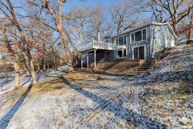 snow covered rear of property featuring a wooden deck