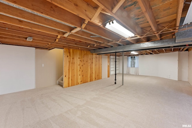 finished below grade area with wood walls, stairway, and carpet flooring