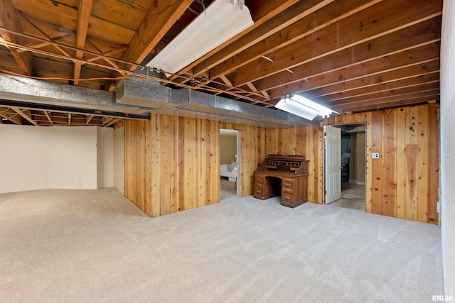 finished basement featuring wood walls and carpet floors