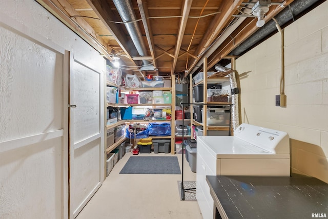 unfinished basement featuring washer / clothes dryer and concrete block wall