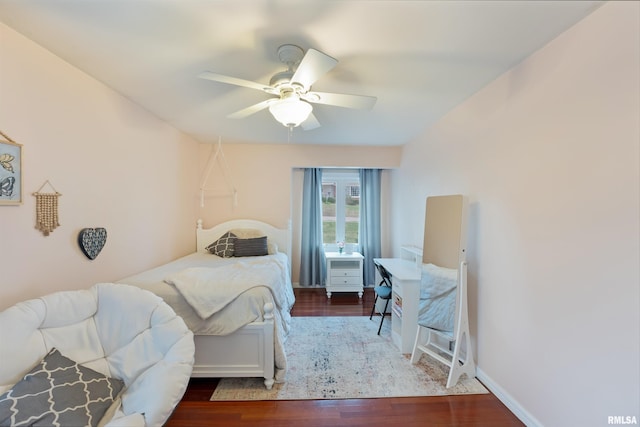 bedroom featuring wood finished floors, baseboards, and a ceiling fan