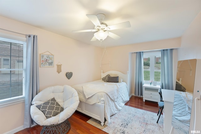 bedroom with ceiling fan, baseboards, and wood finished floors