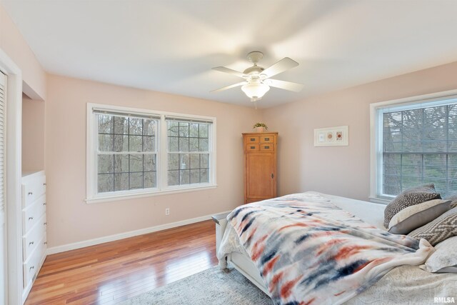 bedroom featuring light wood-type flooring, ceiling fan, and baseboards