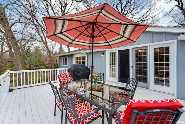 wooden terrace with outdoor dining space and area for grilling