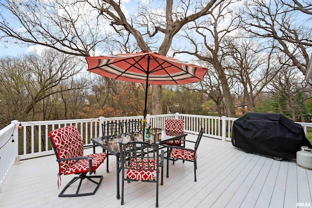 wooden deck with outdoor dining space and a grill