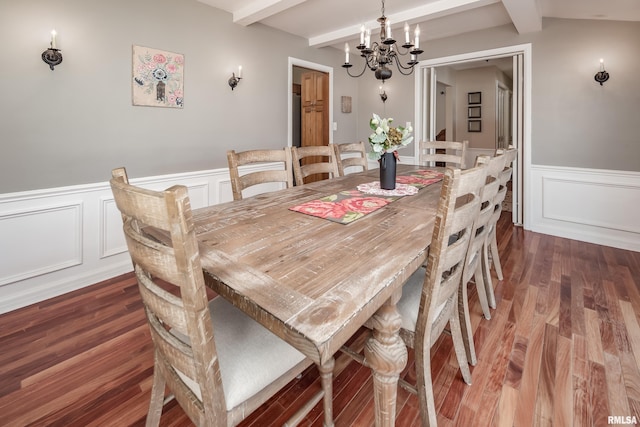 dining space featuring beamed ceiling, dark hardwood / wood-style flooring, and an inviting chandelier