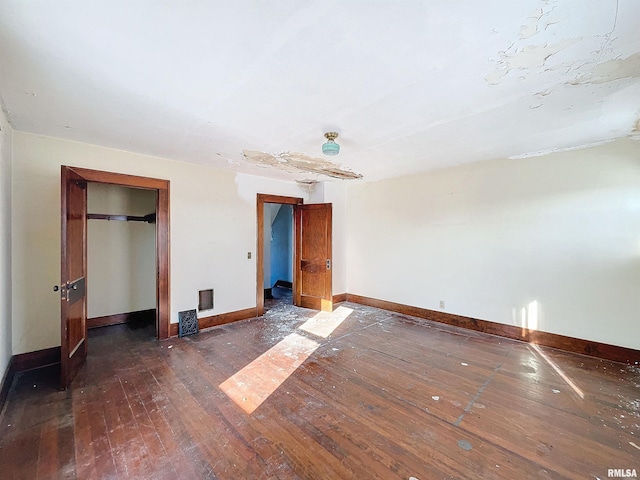 unfurnished bedroom with a closet and dark hardwood / wood-style floors