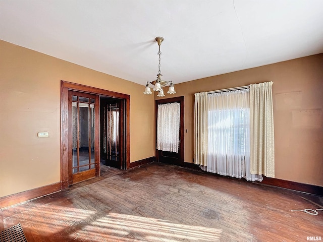 foyer entrance featuring french doors, dark hardwood / wood-style floors, and a notable chandelier