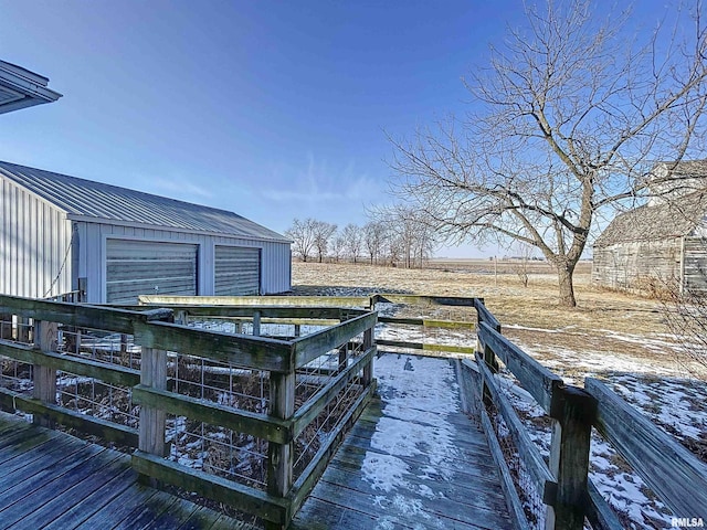 wooden deck with a rural view and an outdoor structure