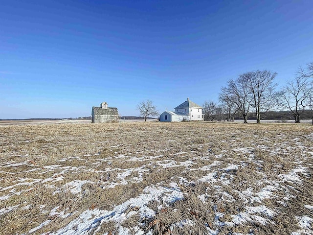 snowy yard featuring a rural view