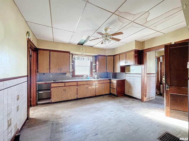 kitchen featuring ceiling fan, a drop ceiling, and sink