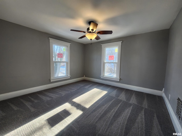 unfurnished room featuring dark colored carpet and ceiling fan