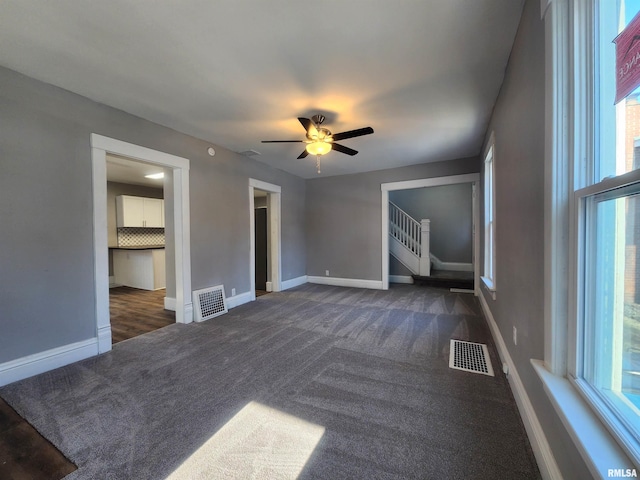 unfurnished bedroom with dark colored carpet and ceiling fan