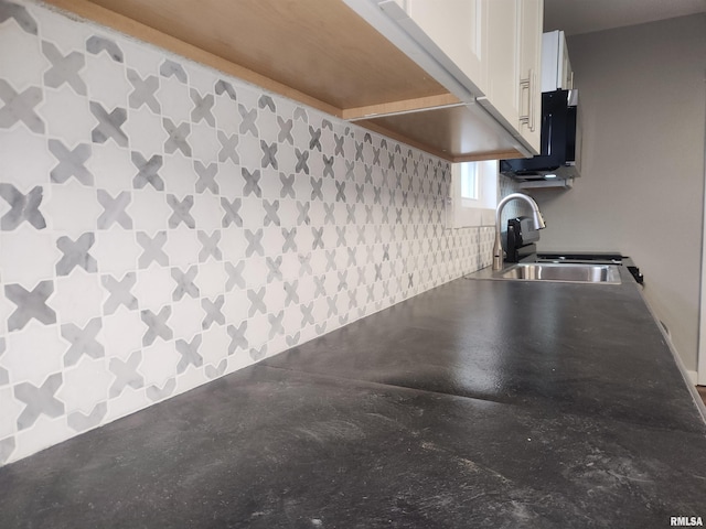 kitchen featuring white cabinetry, sink, and concrete flooring