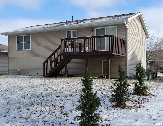 snow covered back of property featuring a wooden deck