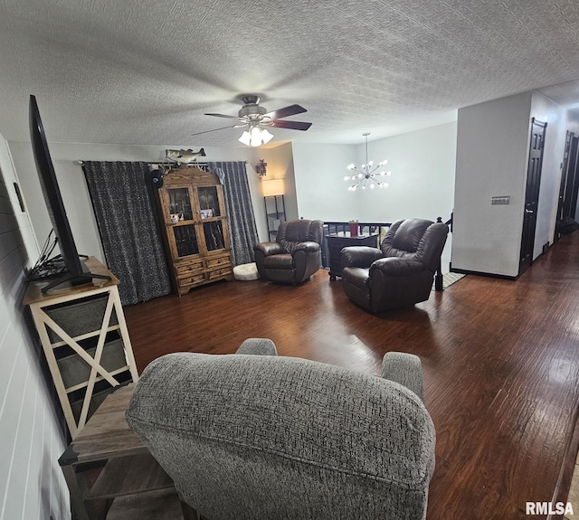 living room featuring ceiling fan with notable chandelier, a textured ceiling, and dark hardwood / wood-style flooring