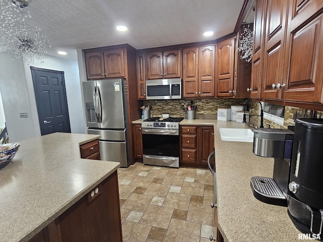 kitchen with stainless steel appliances, sink, backsplash, and a textured ceiling