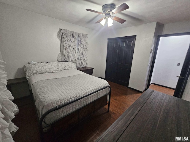 bedroom with dark hardwood / wood-style floors, ceiling fan, and a closet