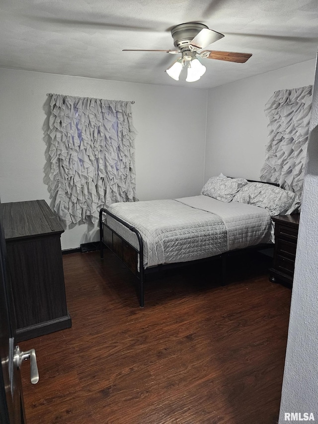 bedroom with ceiling fan and dark hardwood / wood-style flooring