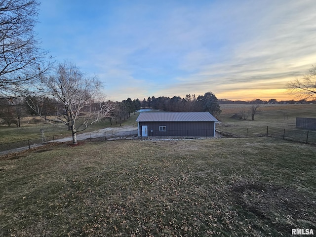 exterior space featuring an outdoor structure, a yard, and a rural view