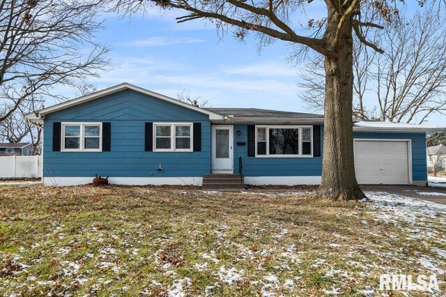 single story home with a garage and a lawn