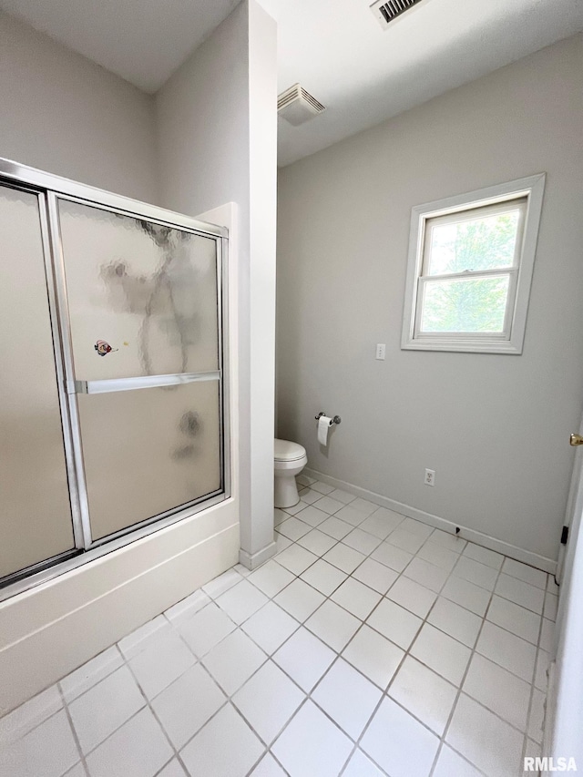 bathroom featuring shower / bath combination with glass door, tile patterned flooring, and toilet