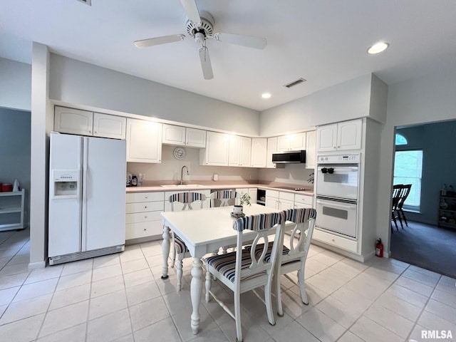 kitchen with white appliances, white cabinets, sink, ceiling fan, and light tile patterned flooring