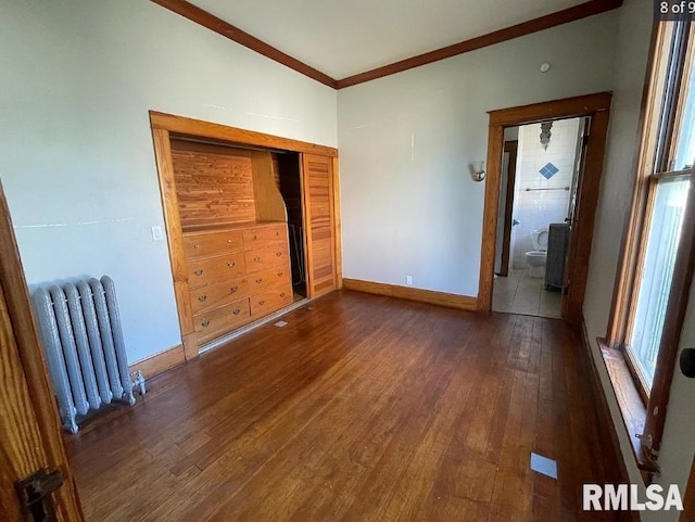 unfurnished bedroom with crown molding, dark wood-type flooring, and radiator