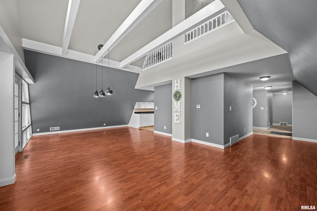 unfurnished living room with beamed ceiling and hardwood / wood-style floors