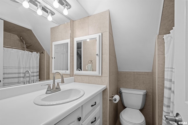 bathroom featuring walk in shower, vanity, toilet, and tile walls