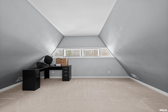 office with lofted ceiling and light carpet