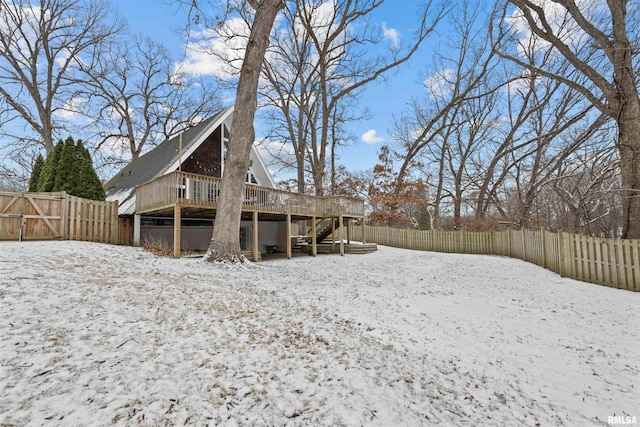 snow covered back of property with a wooden deck