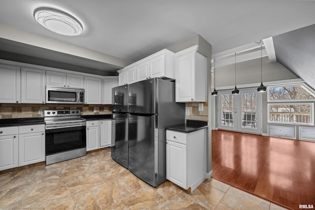 kitchen with backsplash, decorative light fixtures, white cabinetry, and stainless steel appliances