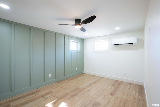 interior space with a wall unit AC, ceiling fan, and light wood-type flooring